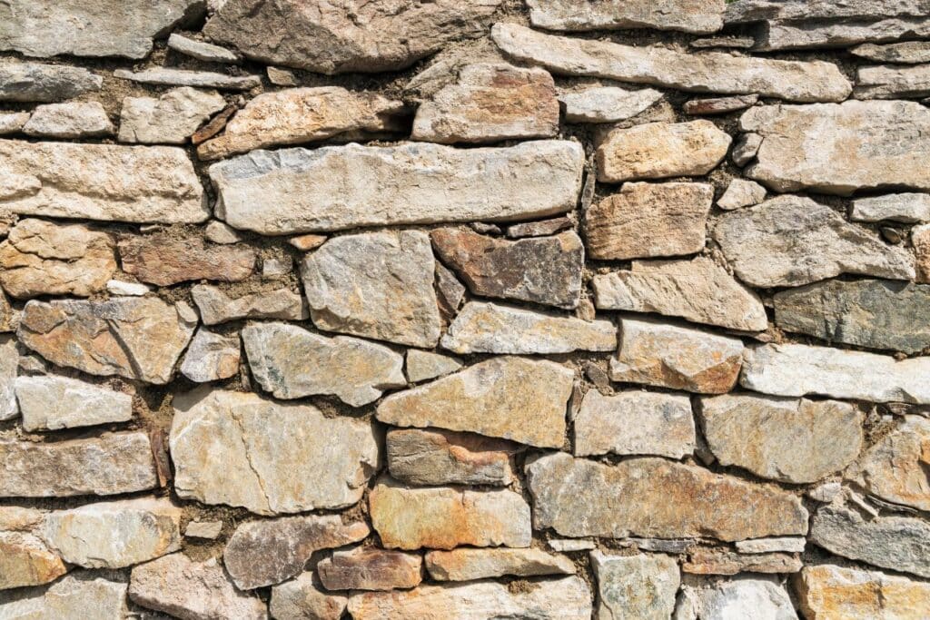Bruchsteine im Garten als traditionelle Trockenmauer mit natürlichem Farbspiel