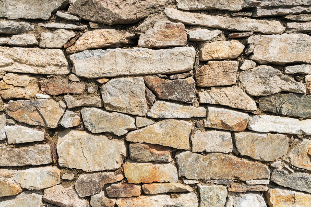 Bruchsteine im Garten als traditionelle Trockenmauer mit natürlichem Farbspiel