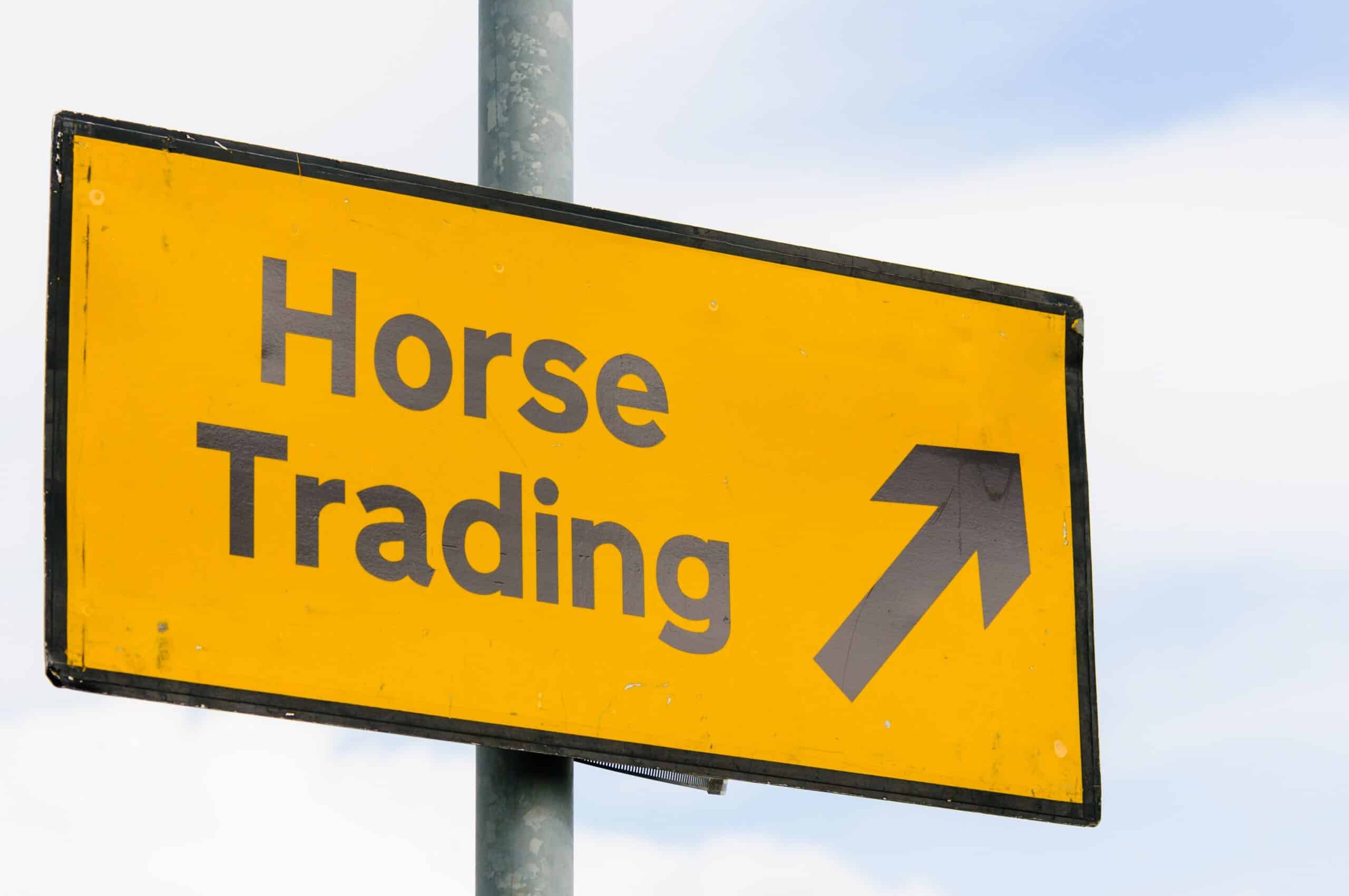A sign says Horse Traiding with an arrow pointing in one direction