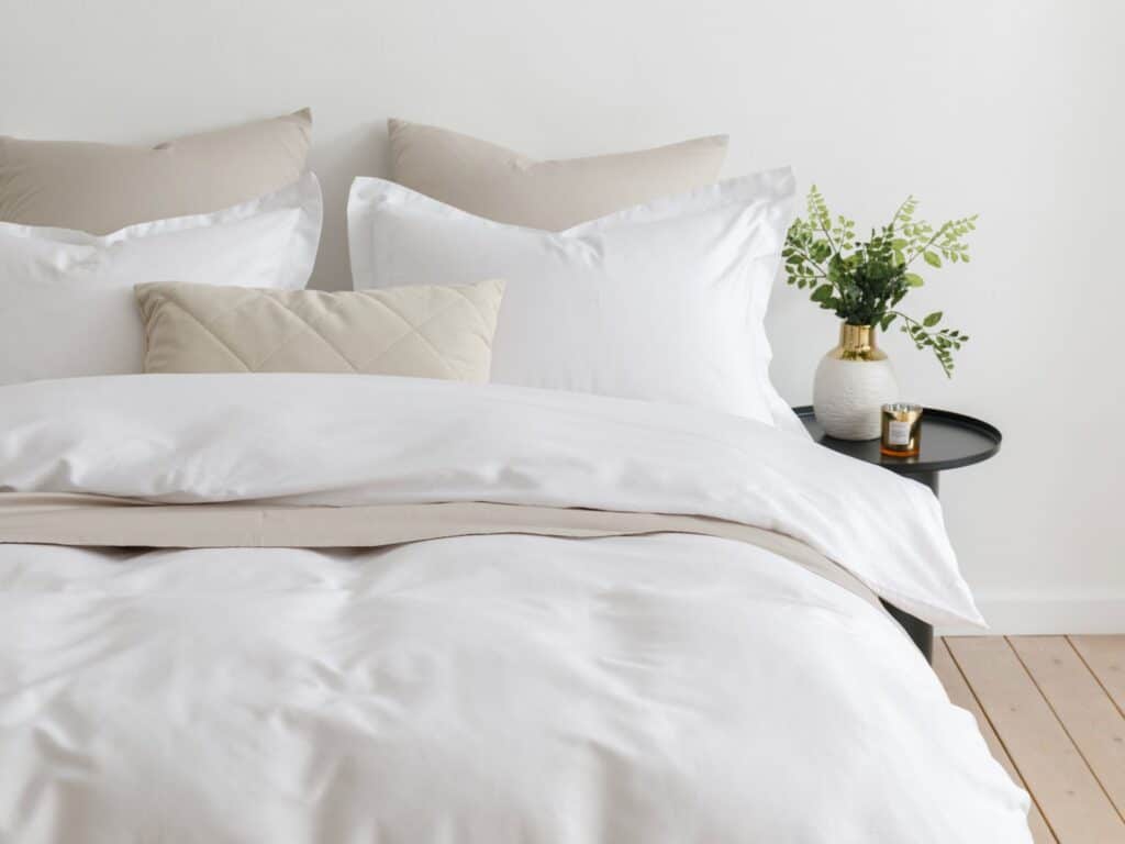 modernes bett mit jersey bettwaesche in weiss und beige – dezente einrichtungsidee mit ruhiger atmosphaere