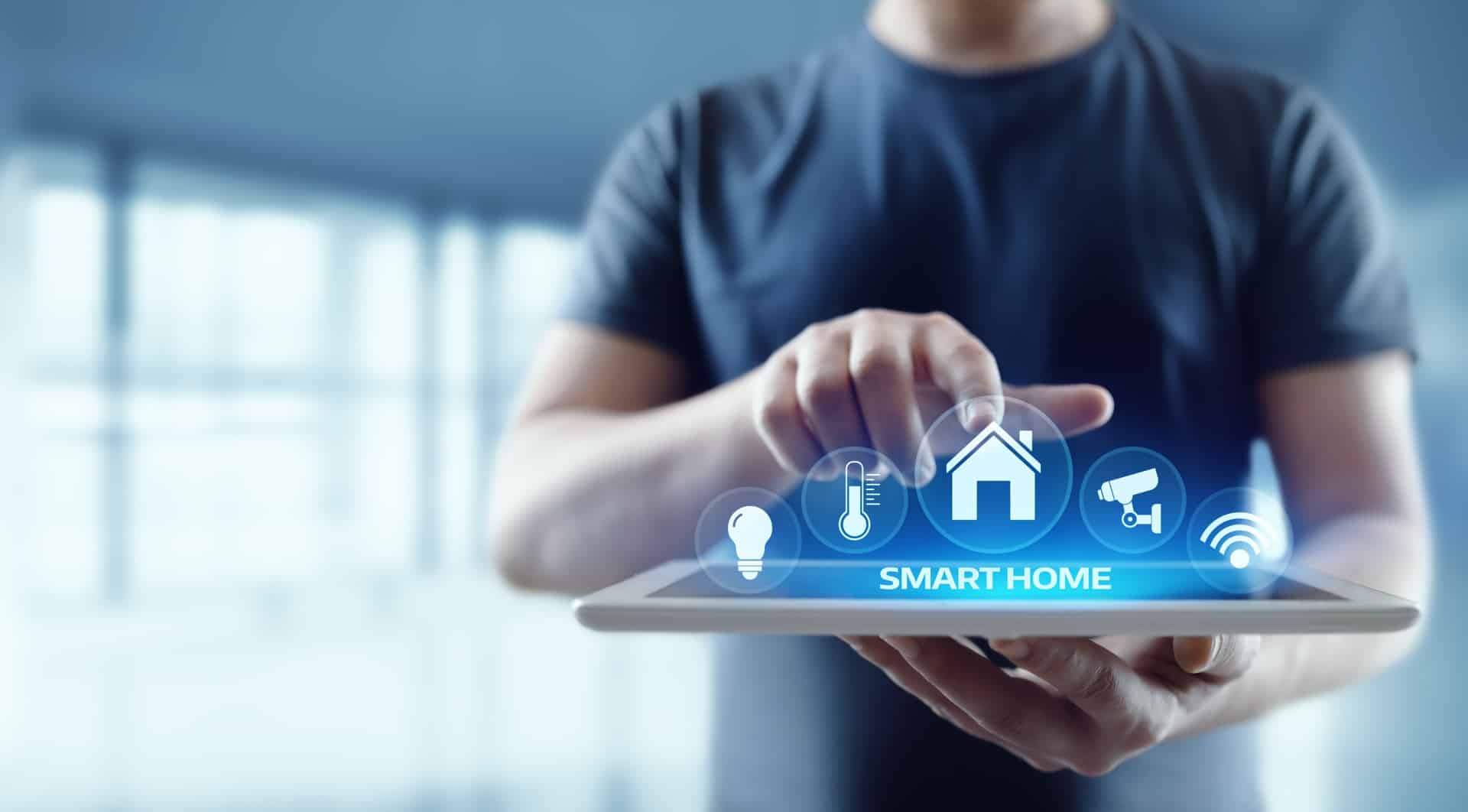 Mann bedient Smart-Home-Funktionen über Tablet | höhenverstellbar Schreibtisch
